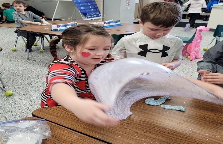 Students making valentines day art projects.